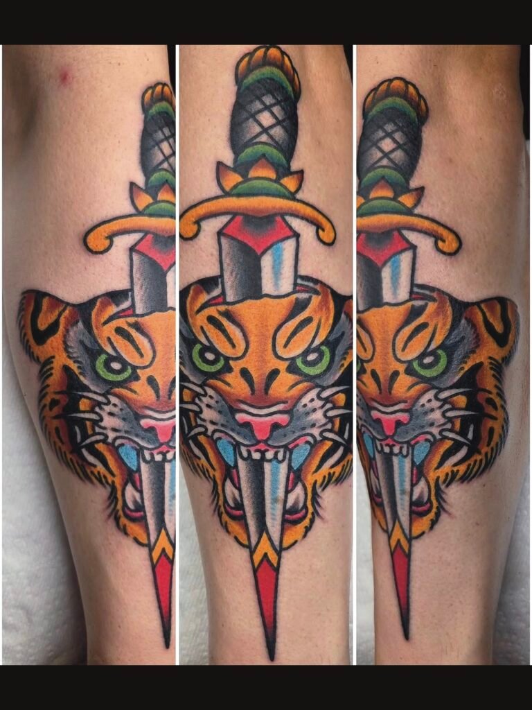 A Neo traditional styled tiger head with a dagger going through the top of its head and out of the tiger’s open mouth. The tiger has an angry and wild expression. It is done on the outer forearm of the wearer. This tattoo was made by Noah Beach, co owner of Near Me Tattoo at 6721 Bells Ferry Rd Ste D110 Woodstock, Ga. 30189
