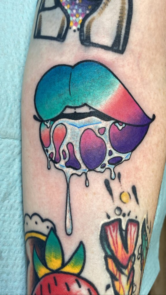 A vaporwave style set of salivating lips. The mouth is watering and slightly puckered. The colors of the lips are purple, pink, and blue. This tattoo was done by Jeremy Moffitt an artist at Near Me Tattoo located at 6721 Bells Ferry Rd Ste D110 Woodstock, Ga. 30189