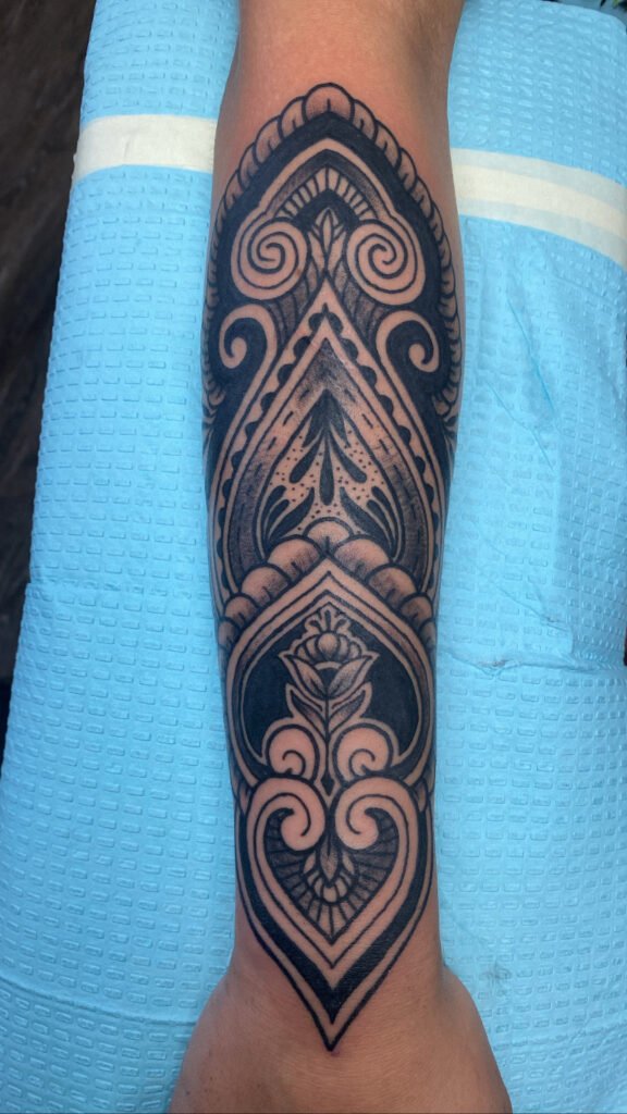 A full forearm of mandala scrollwork. It is done in the blackwork style of shading. It has sacred geometry in its shapes along with a lotus flower near the bottom of the tattoo towards the hand. This tattoo was done by Jeremy Moffitt an artist at Near Me Tattoo located at 6721 Bells Ferry Rd Ste D110 Woodstock, Ga. 30189