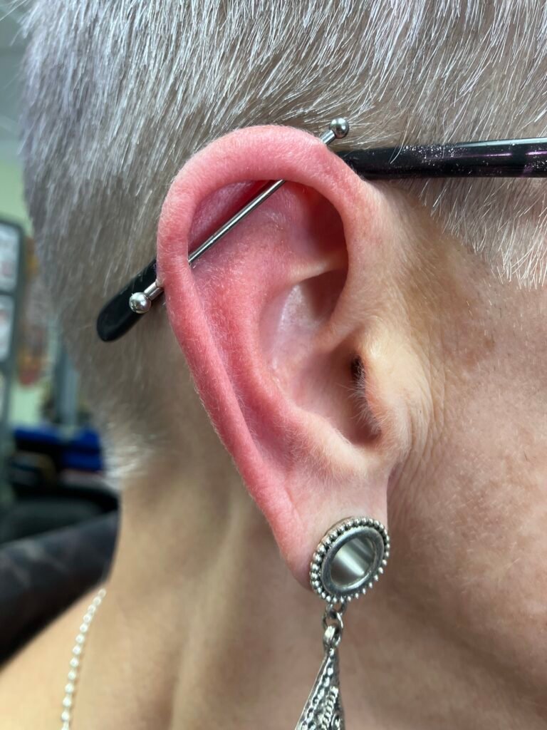 A photograph of an industrial piercing. It is one of the most classic and popular piercings for men and women to get. The jewelry used was made of titanium. This piercing was done by Hope Boyd the body piercer at Near Me Tattoo at 6721 Bells Ferry Rd STE D110 Woodstock, Georgia 30189