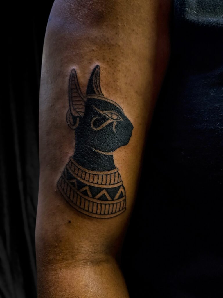 A blackwork style tattoo of the Egyptian Godess Bastet or Bast. It features a traditional style bust style silhouette with fine lines accents. It is worn on the upper arm of the wearer toward the bicep. This is also a really cool client. This tattoo was made by Nathan Heinrich, co owner of Near Me Tattoo at 6721 Bells Ferry Rd Ste D110 Woodstock, Ga. 30189